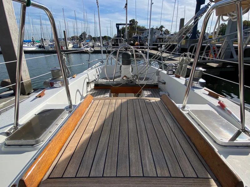 Slide: The Image of 1973 Nautor Swan 44 sailboat deck with wooden flooring, docked at a marina. - 28