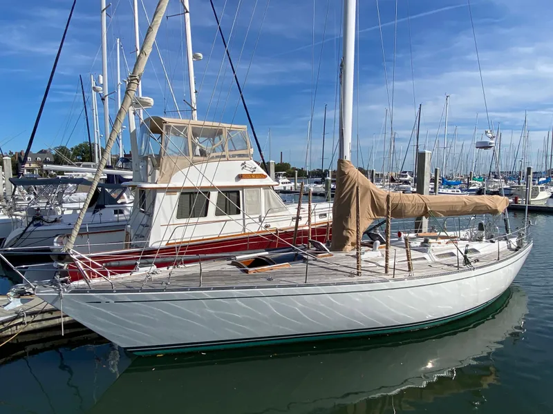 Slide: The Image of 1973 Nautor Swan 44 sailboat docked in a marina under a clear blue sky. - 3