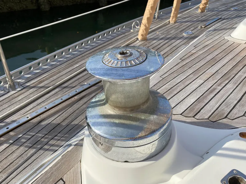 Slide: The Image of Winch on 1973 Nautor Swan 44 sailboat deck, featuring teak wood and metal details. - 31