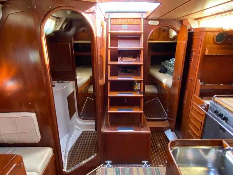 Slide: The Image of Interior of a 1973 Nautor Swan 44 yacht, featuring wooden cabinetry and cozy sleeping quarters. - 34