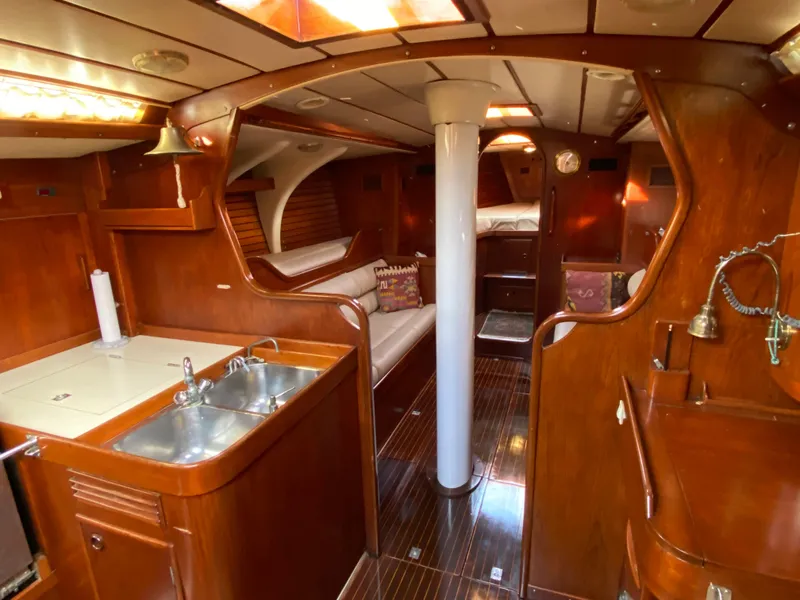 Slide: The Image of Interior of a 1973 Nautor Swan 44 yacht with wooden finishes and a compact kitchen area. - 37