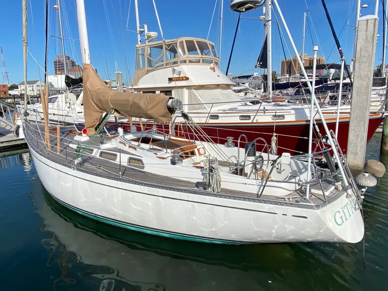 Slide: The Image of 1973 Nautor Swan 44 sailboat docked in a marina, featuring classic design and white hull. - 4