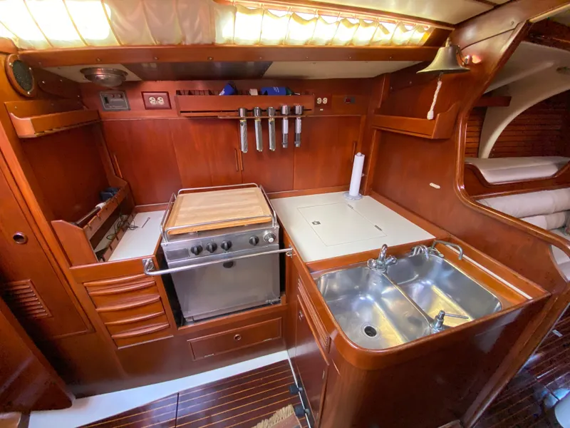 Slide: The Image of 1973 Nautor Swan 44 yacht kitchen with wood cabinetry, stove, and dual sink. - 47