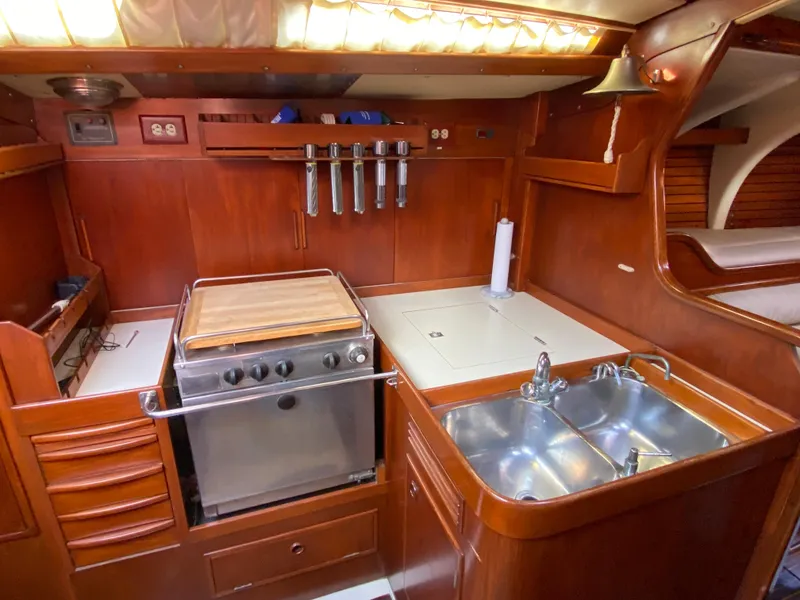 Slide: The Image of Vintage 1973 Nautor Swan 44 yacht kitchen with wood cabinetry and stainless steel sink. - 48