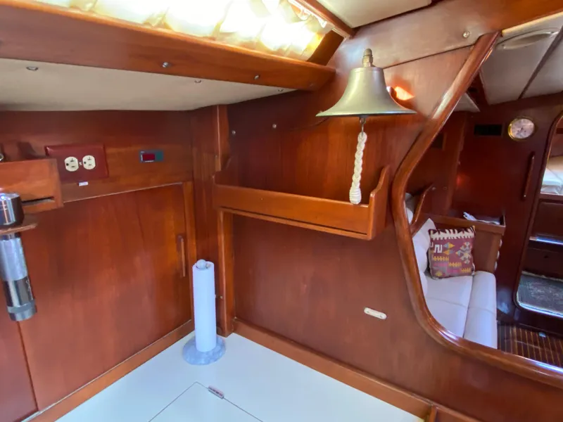 Slide: The Image of Interior of 1973 Nautor Swan 44 yacht with wooden paneling and cozy seating area. - 49