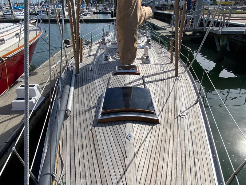 Slide: The Image of 1973 Nautor Swan 44 sailboat deck with wooden finish, docked at marina. - 7