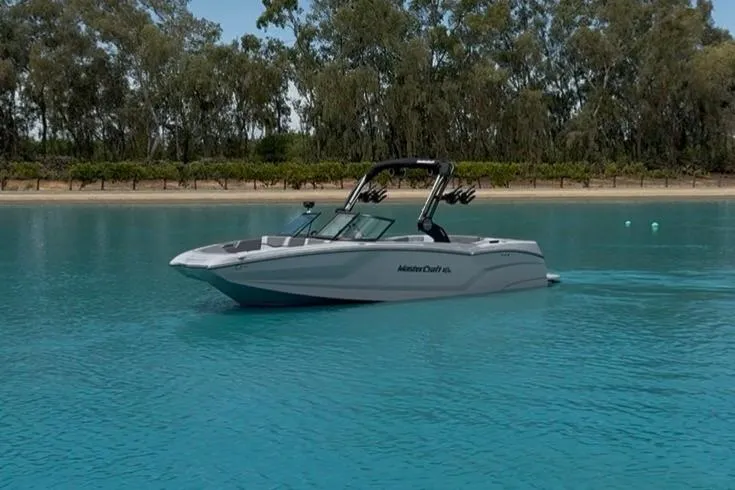 The Image of 2025 MasterCraft NXT24 boat cruising on serene blue water. - 0