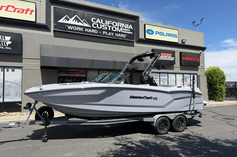 Slide: The Image of 2025 MasterCraft NXT24 boat on trailer outside California Custom dealership. - 11