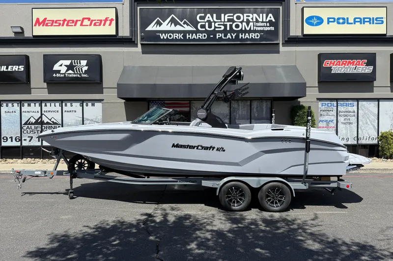 Slide: The Image of 2025 MasterCraft NXT24 boat on trailer outside California Custom dealership. - 12