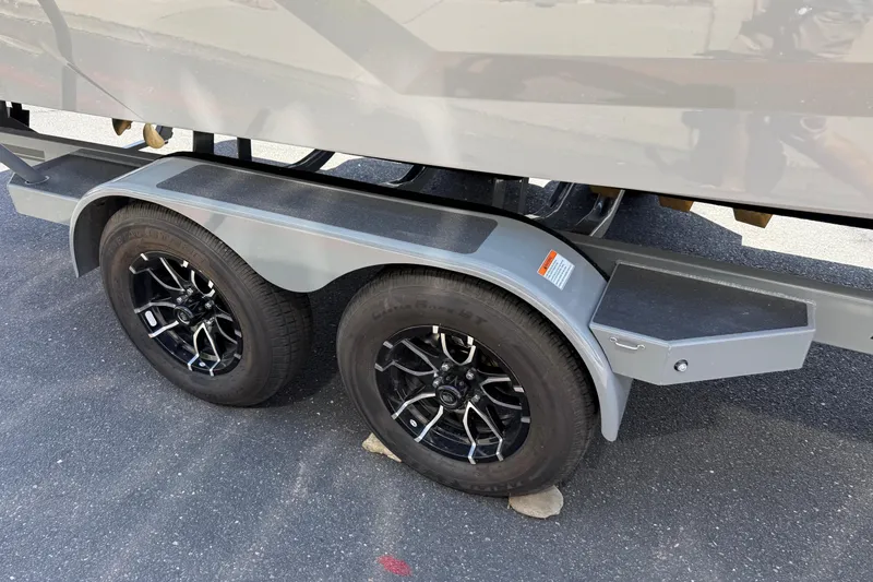 Slide: The Image of Trailer wheels of a 2025 MasterCraft NXT24 boat on asphalt surface. - 21