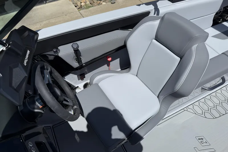 Slide: The Image of 2025 MasterCraft NXT24 boat interior with sleek steering wheel and modern seating design. - 26