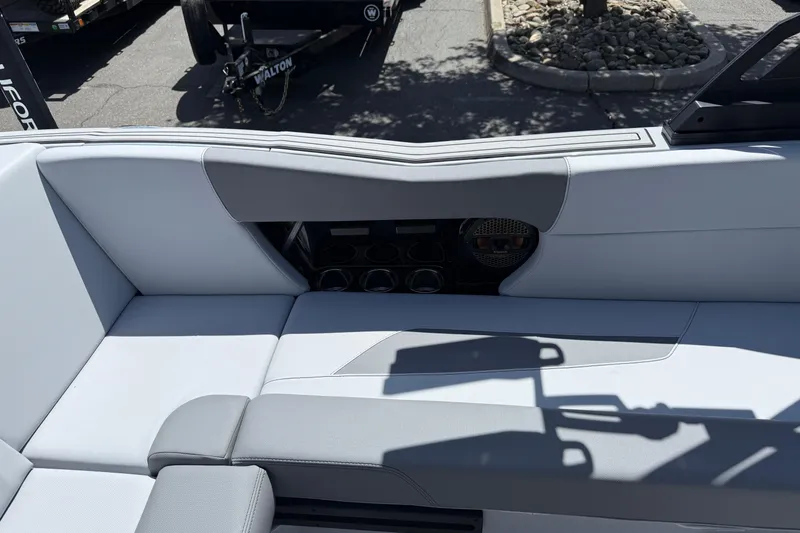 Slide: The Image of 2025 MasterCraft NXT24 boat interior with gray seating and cup holders. - 32