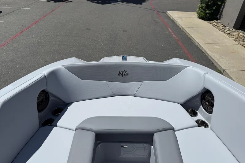 Slide: The Image of 2025 MasterCraft NXT24 boat interior with sleek seating and cup holders. - 37