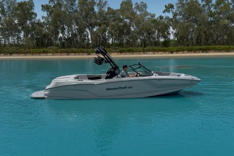 Slide: The Image of 2025 MasterCraft NXT24 boat cruising on clear blue water. - 6