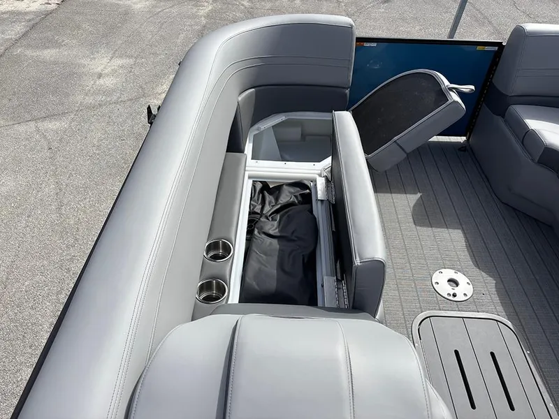 Slide: The Image of 2025 SunCatcher Fusion 324RC boat interior with gray seating and storage compartment. - 13