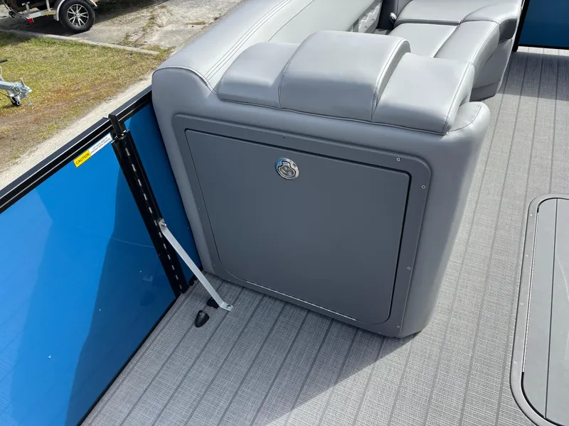 Slide: The Image of 2025 SunCatcher Fusion 324RC boat interior with gray seating and blue panel. - 18