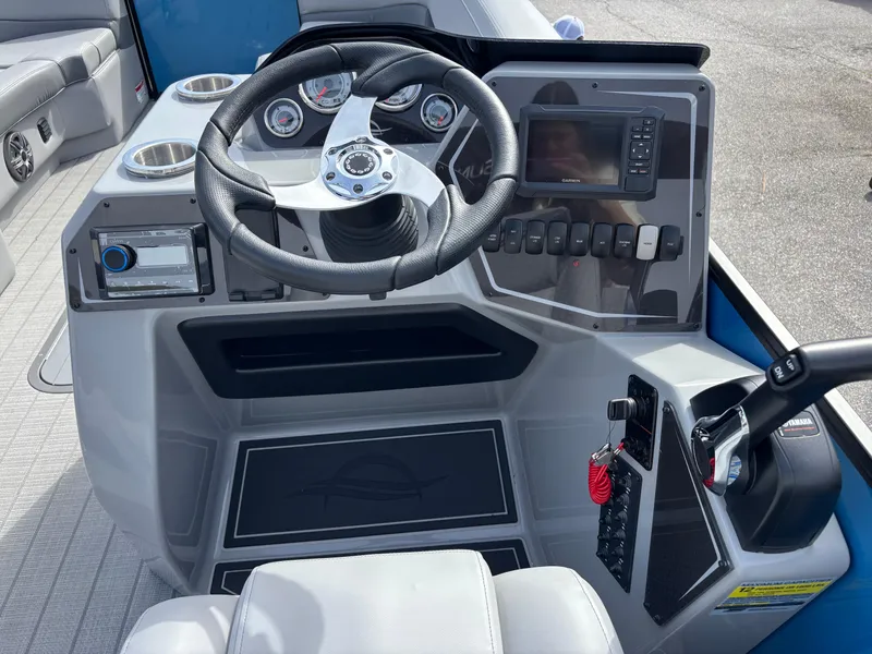 Slide: The Image of 2025 SunCatcher Fusion 324RC boat dashboard with steering wheel, gauges, and control panel. - 19
