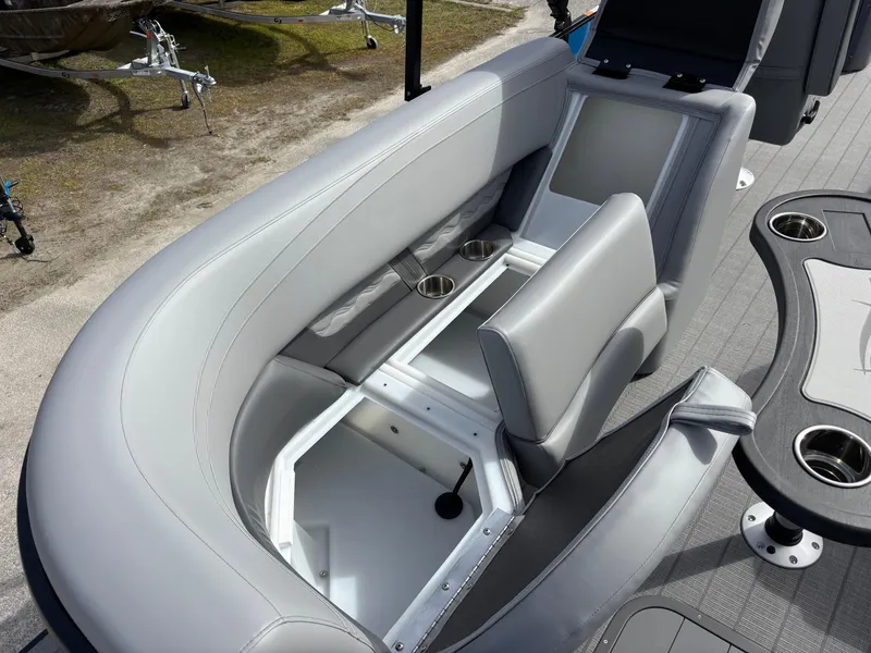 Slide: The Image of 2025 SunCatcher Fusion 324RC boat interior with gray seating and storage compartment. - 21