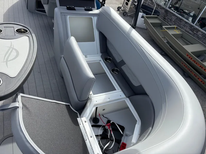 Slide: The Image of 2025 SunCatcher Fusion 324RC boat interior with open storage compartments and seating. - 23