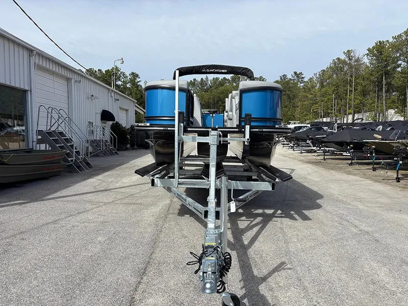 Slide: The Image of 2025 SunCatcher Fusion 324RC pontoon boat on trailer in outdoor storage area. - 3