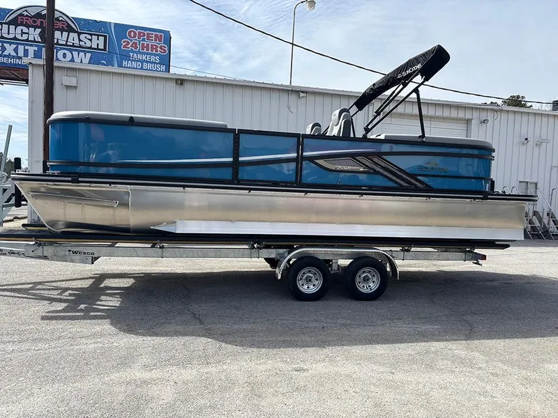 Slide: The Image of 2025 SunCatcher Fusion 324RC pontoon boat on trailer, parked outdoors. - 5