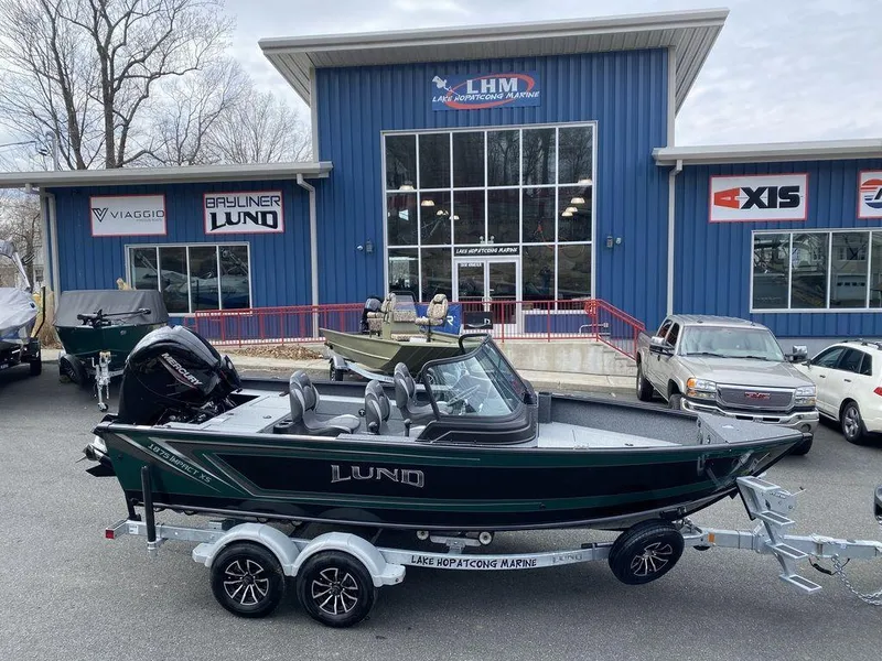 The Image of 2025 Lund 1875 Impact XS Sport boat on trailer outside dealership. - 1