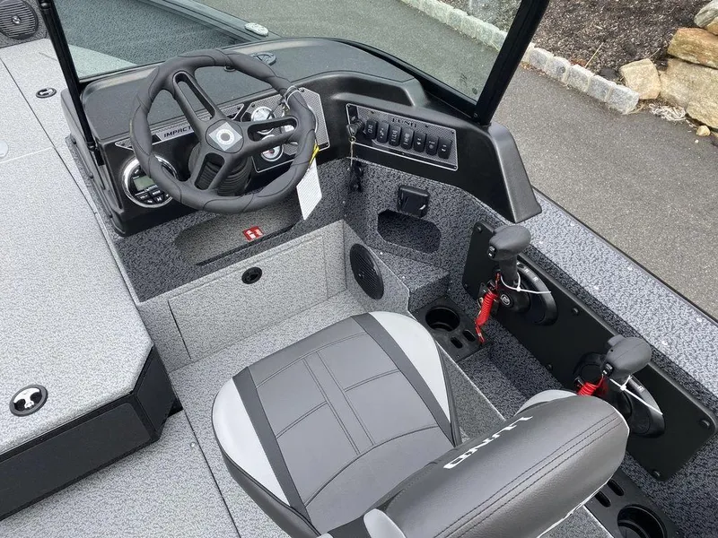 Slide: The Image of 2025 Lund 1875 Impact XS Sport boat interior with steering wheel and seating. - 10