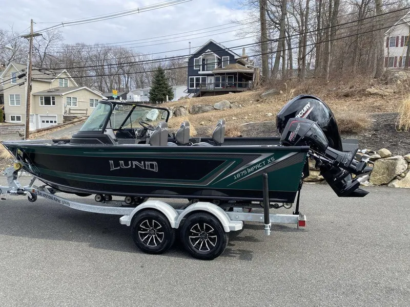 Slide: The Image of 2025 Lund 1875 Impact XS Sport boat on trailer, parked in residential area. - 3