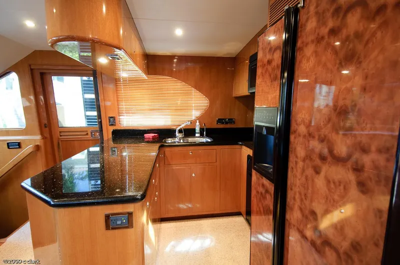 Slide: The Image of Luxurious kitchen interior of 2005 Ocean Alexander 58 Motoryacht with wood finish and black countertops. - 4