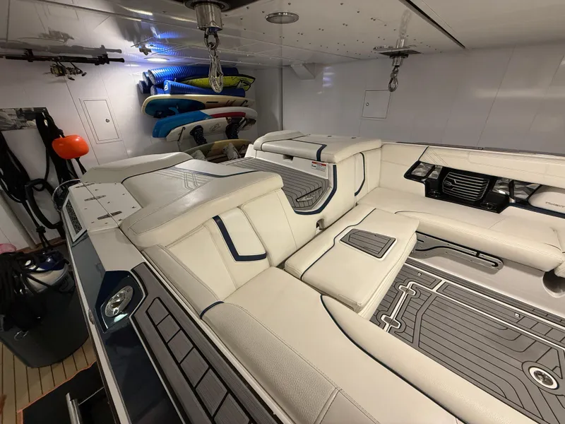 Slide: The Image of 2020 Nautique Super Air G23 interior with white seating and surfboards in storage. - 8