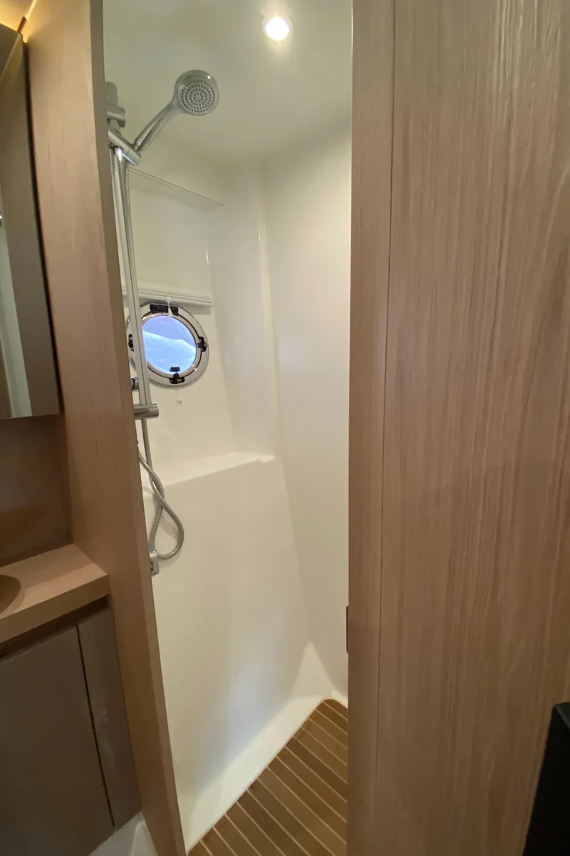 Slide: The Image of 2020 Beneteau Gran Turismo 50 Sportfly shower with wooden flooring and porthole window. - 37