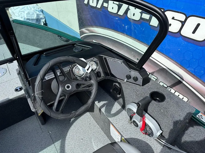 Slide: The Image of 2025 Lund 1650 Rebel XL Sport boat dashboard with steering wheel and controls. - 15