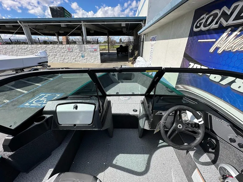 Slide: The Image of 2025 Lund 1650 Rebel XL Sport boat interior with steering wheel and dashboard. - 17