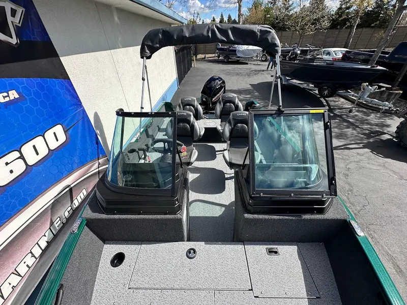 Slide: The Image of 2025 Lund 1650 Rebel XL Sport boat, dual windshields, outdoor display, sunny day. - 20