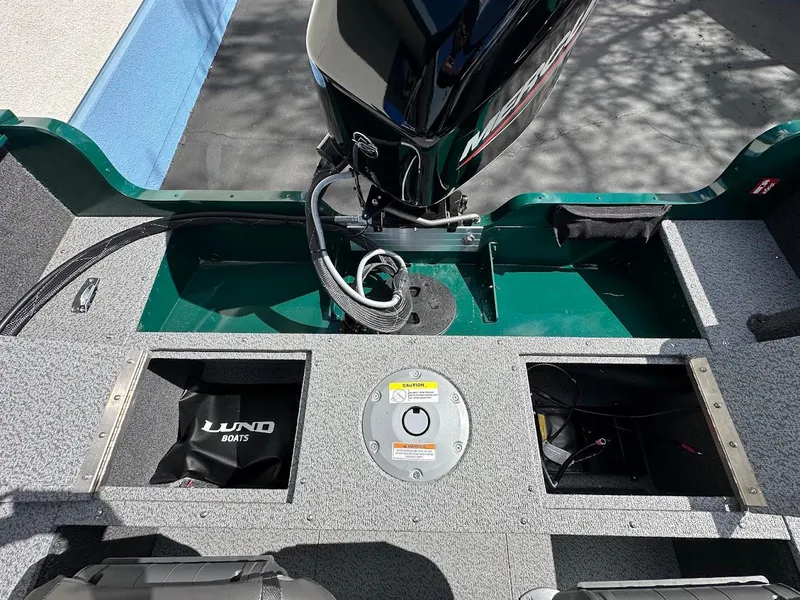 Slide: The Image of 2025 Lund 1650 Rebel XL Sport boat interior with motor and storage compartments. - 25