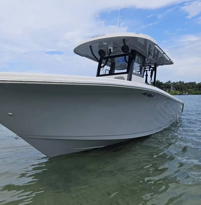 Slide: The Image of 2023 Sea Pro 320 DLX Center Console boat on calm water under a cloudy sky. - 35