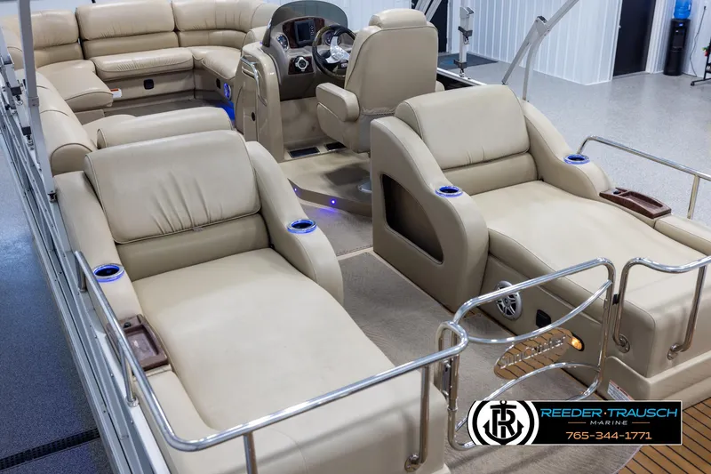 Slide: The Image of 2014 SunCatcher Elite 324 pontoon boat with luxurious beige seating and modern dashboard. - 11