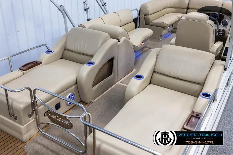 Slide: The Image of 2014 SunCatcher Elite 324 pontoon boat with luxurious beige seating and cup holders. - 12
