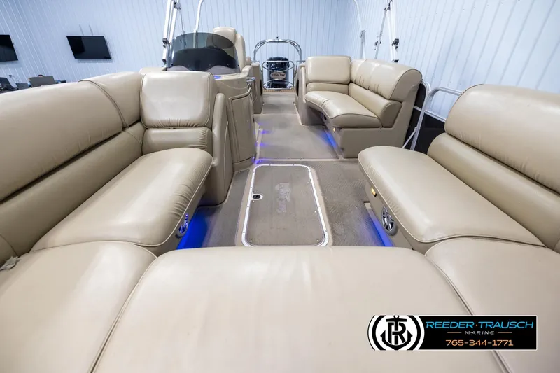 Slide: The Image of 2014 SunCatcher Elite 324 pontoon boat interior with beige seating and blue accent lighting. - 13