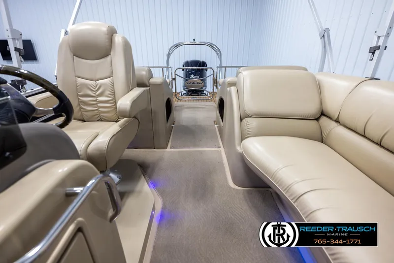 Slide: The Image of 2014 SunCatcher Elite 324 boat interior with beige seating and steering area. - 14