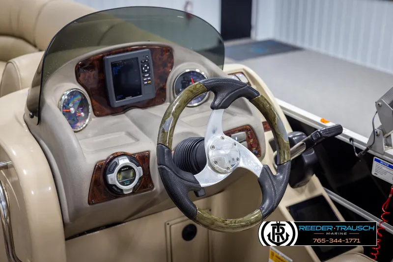 Slide: The Image of 2014 SunCatcher Elite 324 boat dashboard with steering wheel and control panel. - 26