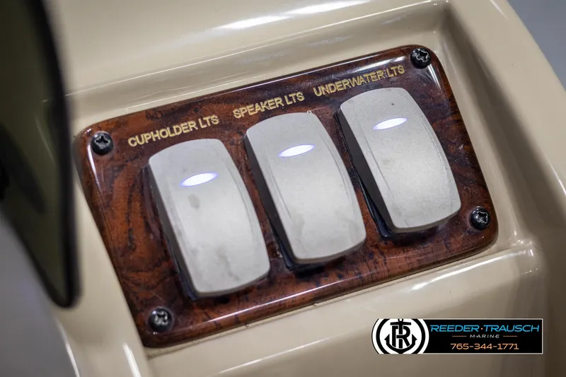 Slide: The Image of Control panel of 2014 SunCatcher Elite 324 with light switches for cupholder, speaker, and underwater. - 32