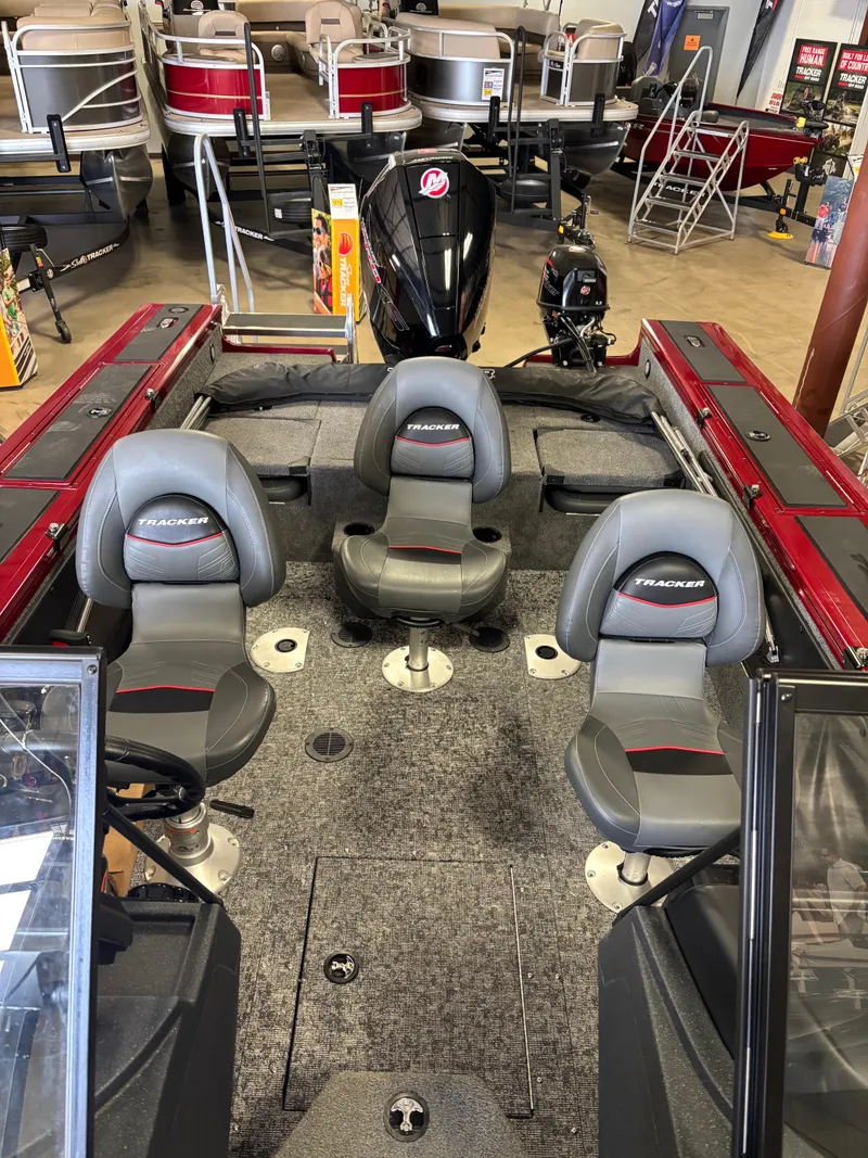 Slide: The Image of 2025 Tracker Targa V-19 Combo boat interior with seating and motor in showroom. - 7