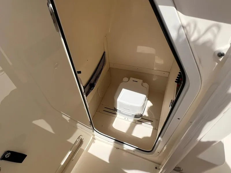 Slide: The Image of 2022 Scout 215 XSF boat interior with compact marine toilet. - 11