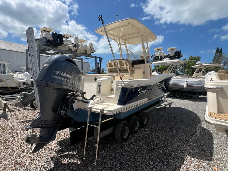 Slide: The Image of 2022 Scout 215 XSF boat with Yamaha outboard motor on trailer, parked outdoors. - 2