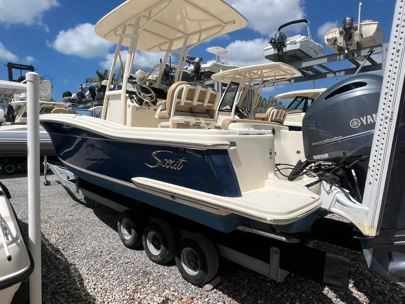 Slide: The Image of 2022 Scout 215 XSF boat with Yamaha engine on trailer, under clear blue sky. - 3