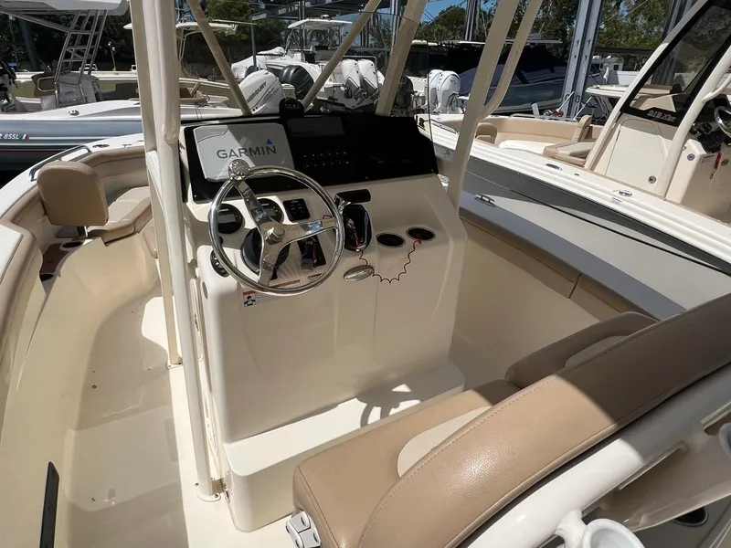 Slide: The Image of 2022 Scout 215 XSF boat interior with Garmin navigation system and beige seating. - 7