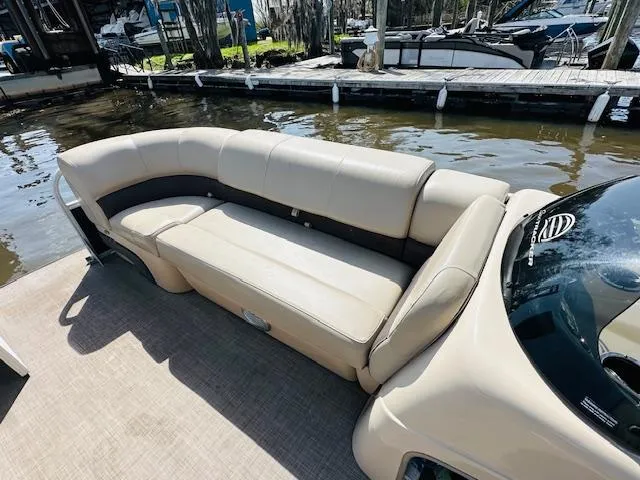 Slide: The Image of 2019 Sun Tracker Party Barge 20 DLX with beige seating by the water. - 10