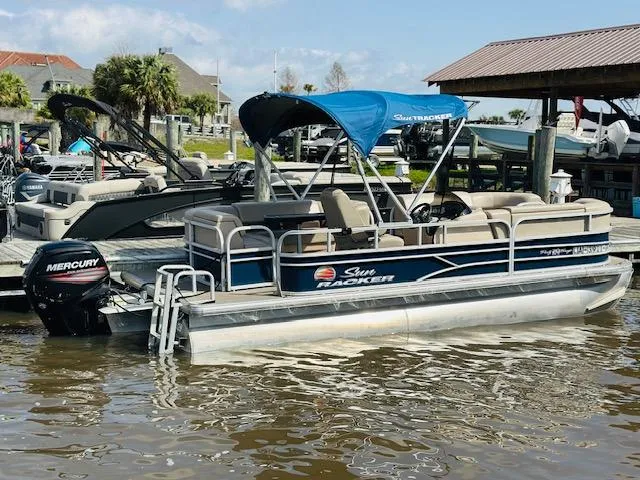 Slide: The Image of 2019 Sun Tracker Party Barge 20 DLX pontoon boat docked with blue canopy. - 16