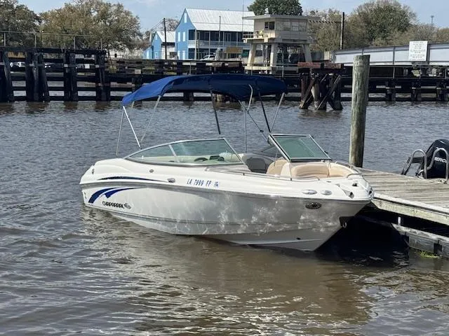 Slide: The Image of 2007 Chaparral 204SSI boat docked on calm water with blue canopy. - 3